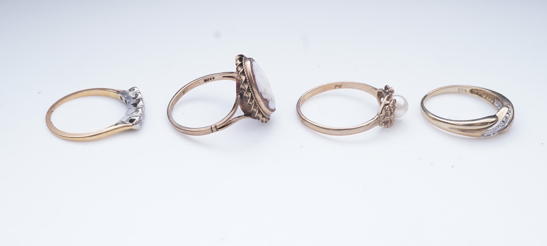 A collection of four rings and a pendant